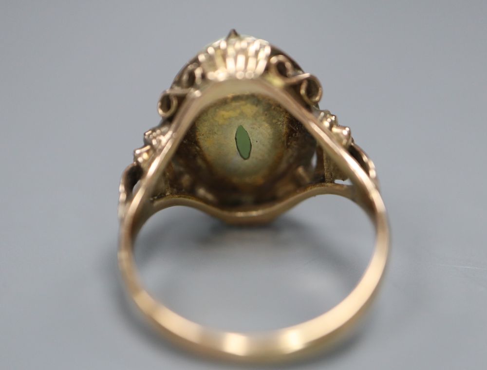 A 14k yellow metal and oval cabochon jade set ring, size L/M, gross 5 grams.